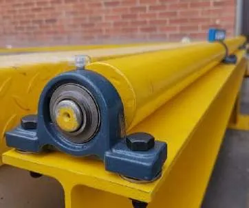 Rodillo con chumacera sobre estructura amarilla